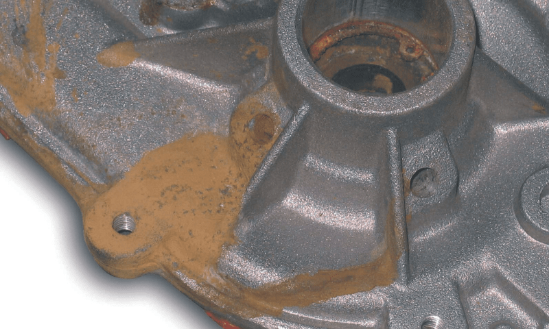 A worn forklift water pump with signs of coolant leak